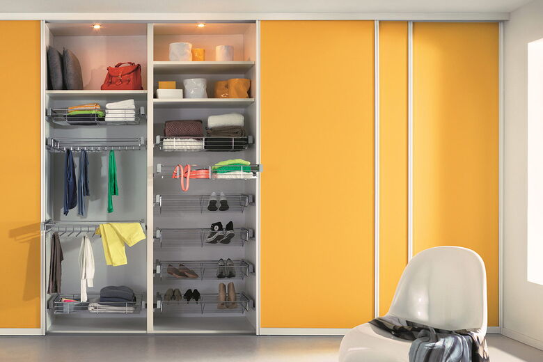 Begehbarer Kleiderschrank mit Dekorschiebetüren in kräftigen Farben und Aluminiumprofilen.